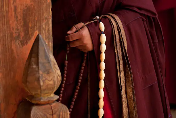 A Buddhist monk in a monastery in rural Bhutan drapes a sting of ivory prayer beads from his outstretched arm. Demand for ivory in religious circles throughout Asia has escalated illicit trade in recent years, threatening wild elephant populations.
