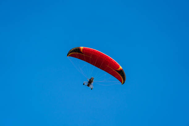 istock Flying with paramotor in the blue sky - Man riding paramotor in the blue sky background 1774192916