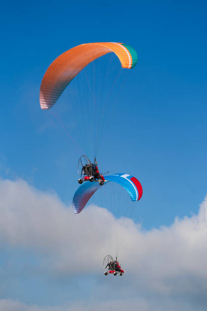 istock Flying with paramotor in the blue sky - Man riding paramotor in the blue sky background 1774192923