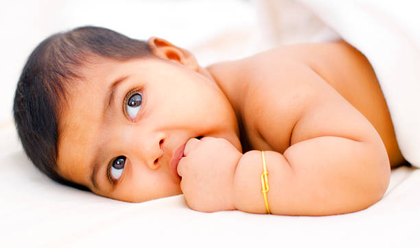 indian bebé menina - thumb sucking cute small lying down imagens e fotografias de stock