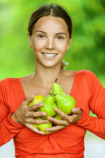 young woman in red blouse with pears stock photo