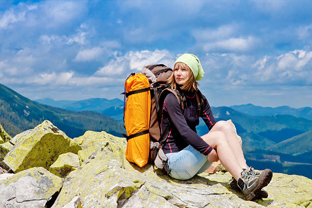 istock Young girl with backpack sitting on a cliff 177421642