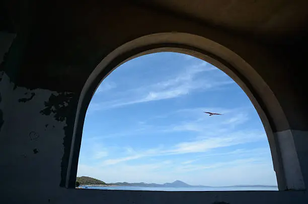 View through an archway on the sea and summer sky with a seagull