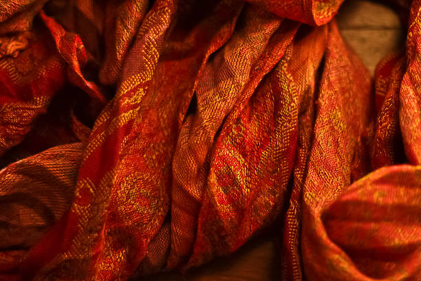 istock Red and Gold Scarf on Wooden Table 177422632