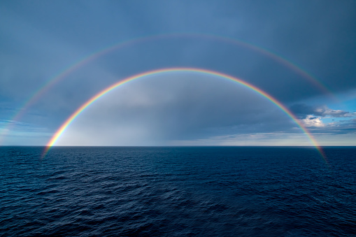 View of a beautiful full double rainbow over the sea.