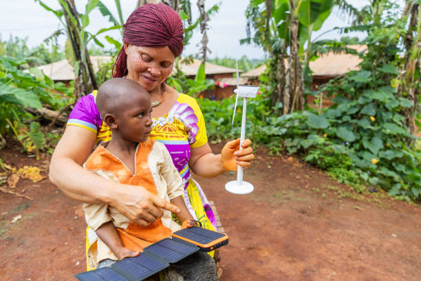 una madre albina enseña a su hijo sobre la energía solar con paneles solares y turbinas eólicas - solar energy solar power station student alternative energy fotografías e imágenes de stock
