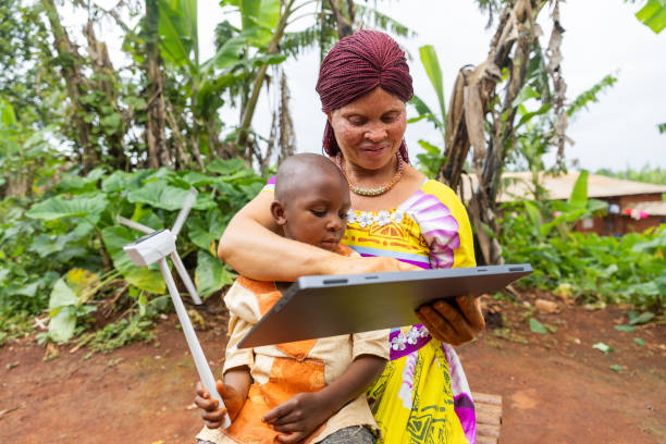 una madre albina africana con la ayuda de una tableta sermonea a su hijo sobre la energía solar - solar energy solar power station student alternative energy fotografías e imágenes de stock