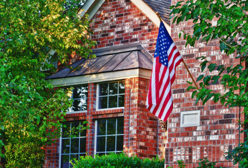 Patriotic American flag displayed in front of southern home