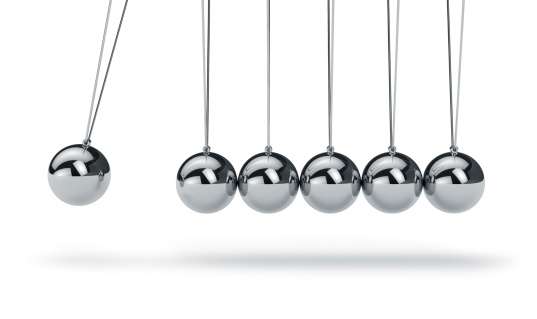 Newtons cradle with metal balls hanging in a line