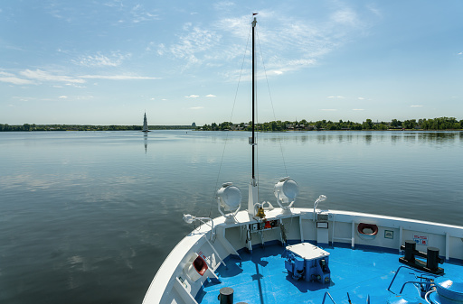 The cruise steamship sails past the ancient Russian town of Kalyazin, which has gone under water, where the bell tower from the flooded church sticks out above the surface of the water