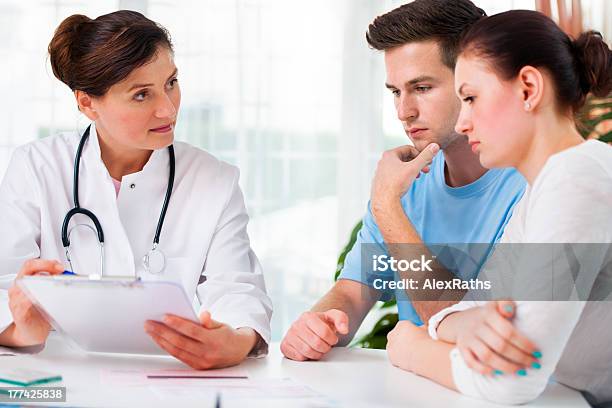 A Female Doctor Giving A Yong Couple Medical Consultation Stock Photo - Download Image Now