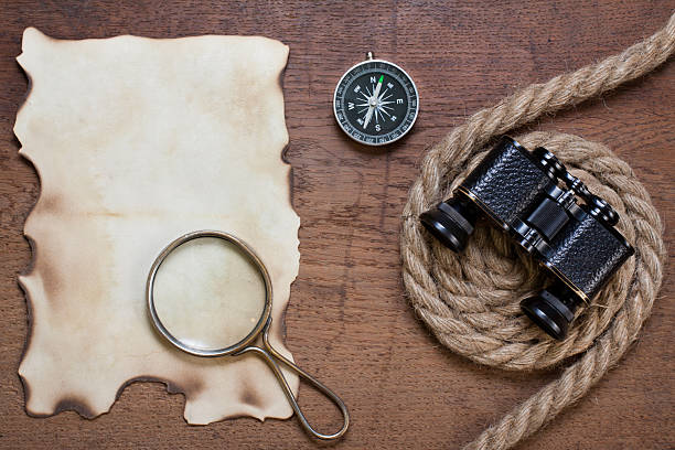 istock Burnt paper, compass, magnifying glass, binoculars, rope on wood 177426184