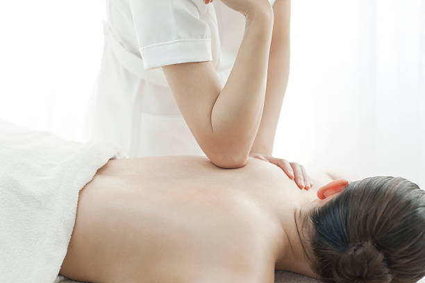 los masajes de un esteticista que respaldo - massaging human arm obscured face only women fotografías e imágenes de stock