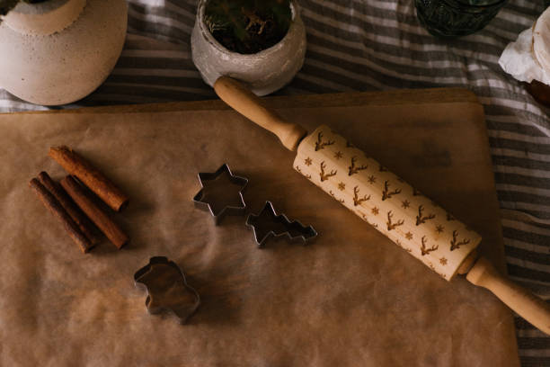 istock Ginger cookie molds, rolling pin and cinnamon sticks on a sheet of parchment on the table 1774269236