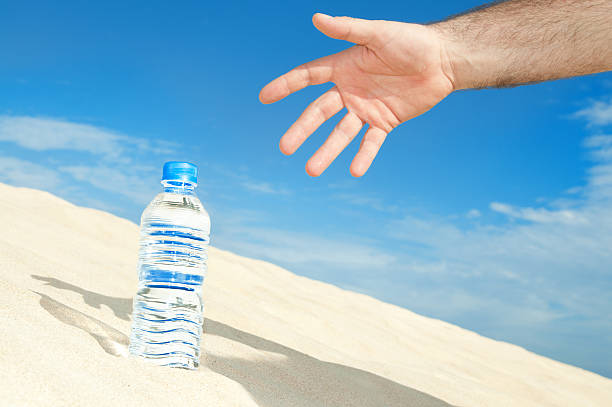 bouteille d'eau dans le désert - thirsty desert men reaching photos et images de collection