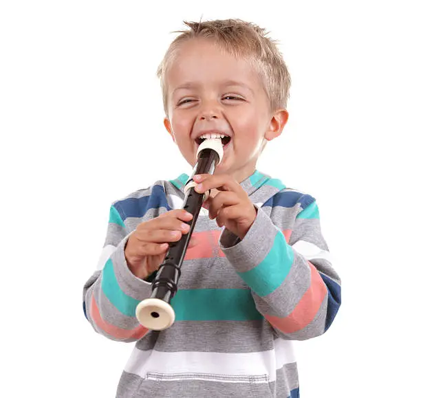 Young boy practicing his recorder on white background