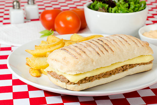 Tuna Melt Sandwich Cheese and tuna panini in a ciabatta bread served with salad and chips. melting tuna cheese toast stock pictures, royalty-free photos & images