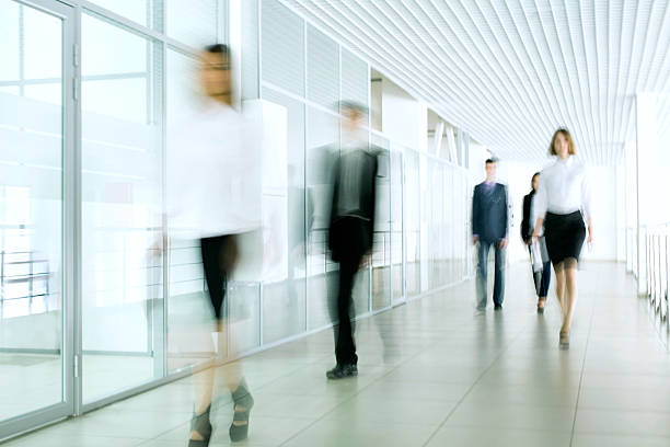 A blurred photo of business people in an office stock photo