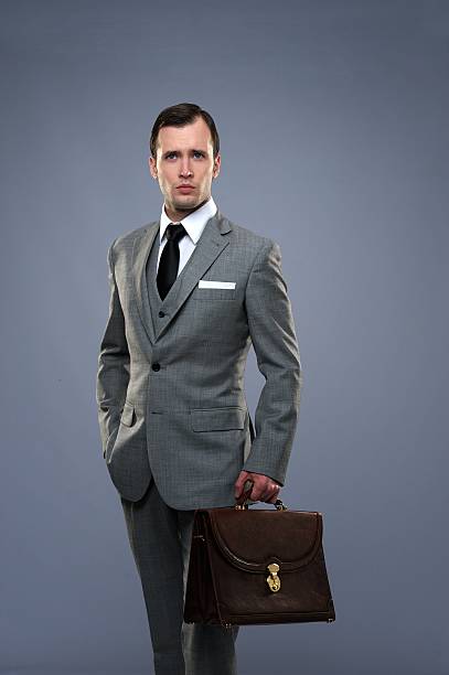 istock A businessman in a gray suit holding a suitcase 177429634