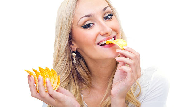 istock Young woman eating chips, studio-shot 177430855