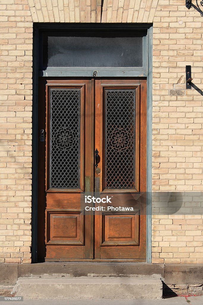 Double Wooden Doors in Brick Building Double wooden doors in an old brick building. Architectural Feature Stock Photo