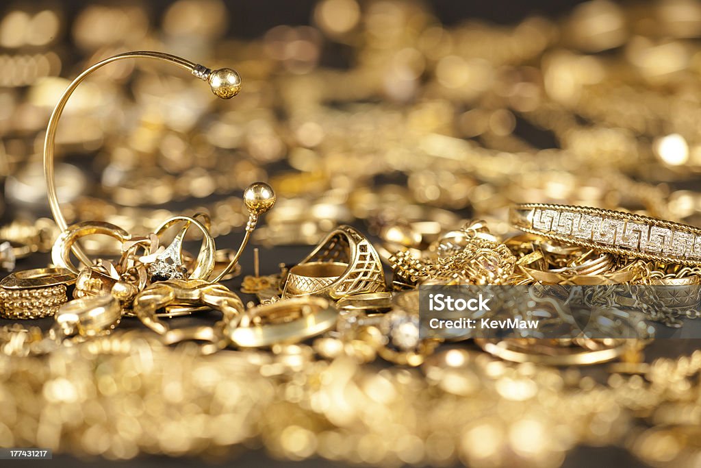 Scrap Gold Collection Table of scrap gold being inspected.Focal point on the two bracelets. Gold - Metal Stock Photo