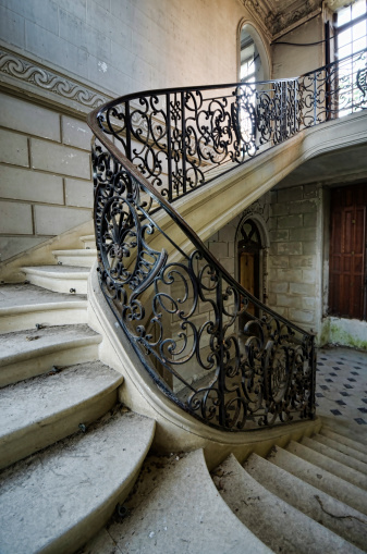 A grand staircase in an abandoned chateau