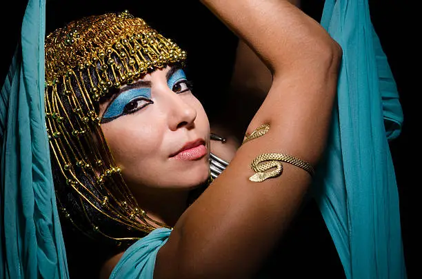 Woman in Cleopatra costume looks seductively at the camera