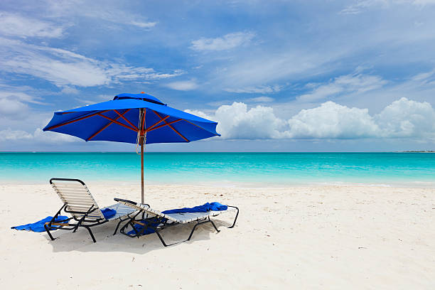 Two chairs under umbrella Two chairs under umbrella on beautiful tropical beach in Turks and Caicos providenciales stock pictures, royalty-free photos & images