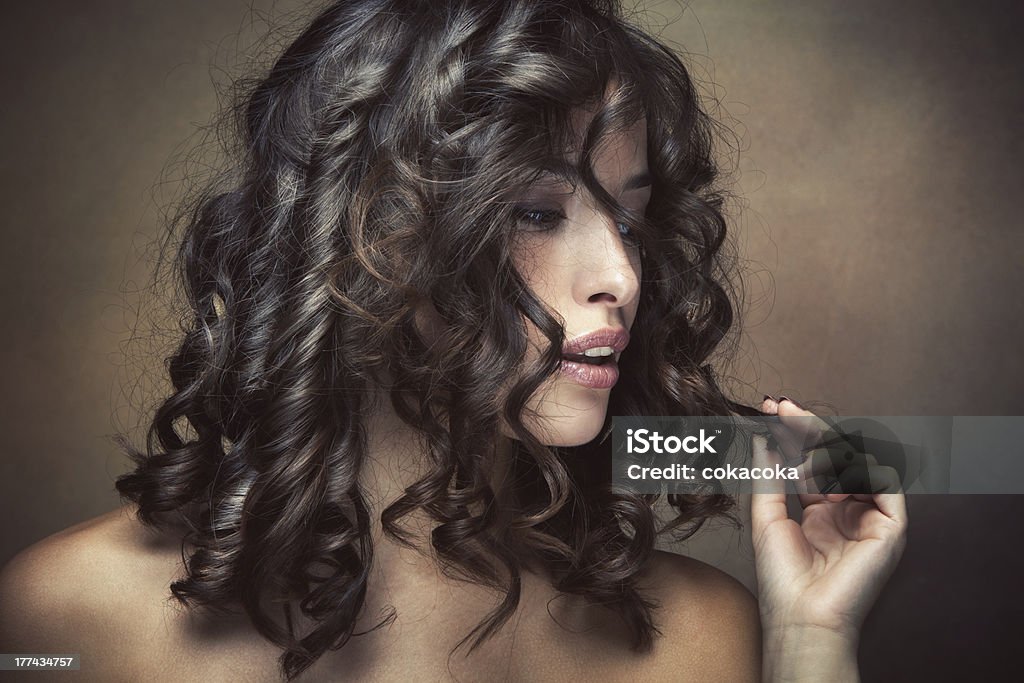 shiny curly hair sensual brunette woman with shiny curly silky hair studio shot Adult Stock Photo