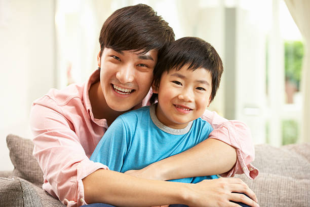 istock Chinese Father And Son Relaxing On Sofa At Home 177435073