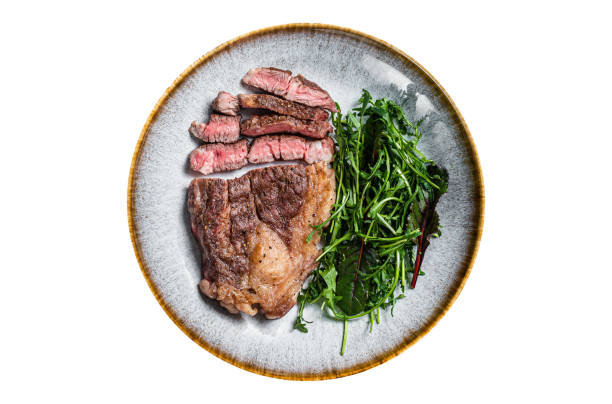 istock BBQ Roasted Chuck Roll  Tender beef steak with salad in plate.  Isolated on white background. 1774354599