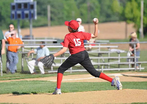 little league baseball pitcher throwing the ball from the pitcher's mound