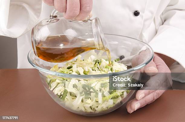 Female Chef Fills Some Oil Into A Salad Stock Photo - Download Image Now - Bowl, Brown, Chef