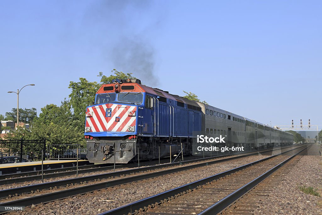 Double-decker commuter train approaching station Double-decker commuter train arriving at a station in the suburbs Commuter Train Stock Photo