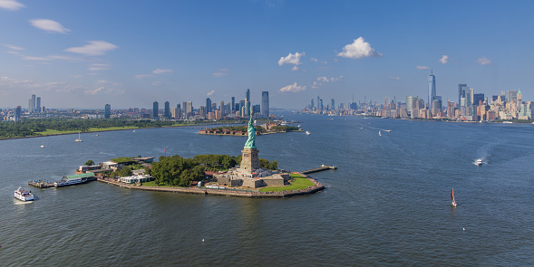 Panoramic, high angle view of Liberty island and the Statue of Liberty with Jersey City and Lower Manhattan in the background, New York City, USA