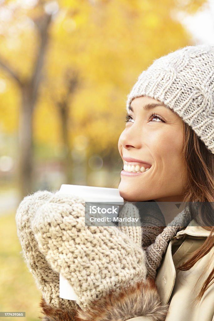 Autumn woman drinking coffee Autumn xwoman drinking coffee. Fall concept of young xwoman enjoying hot drink from disposable coffee cup outdoors in fall landscape. Serene happy mixed race Asian / Caucasian female model in Autumn in city forest park. 20-29 Years Stock Photo