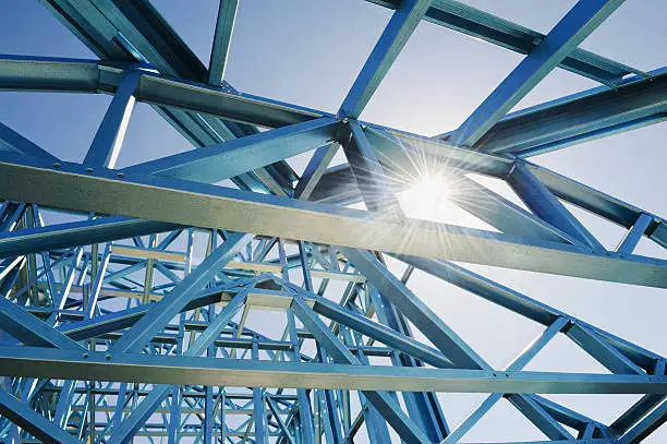 New home under construction using steel frames against a sunny sky.