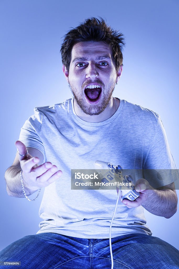 Scioccato uomo con Gamepad - Foto stock royalty-free di Abbigliamento casual