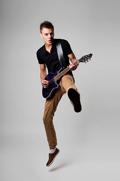 rockstar com guitarra salto - men artist guitarist guitar imagens e fotografias de stock