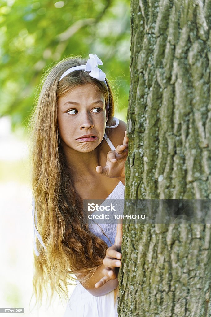 Peur des jeunes peeping derrière un arbre - Photo de Adolescence libre de droits
