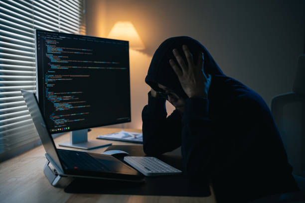 istock Hacker man wearing glasses and hood depression or serious mistake for hack network security system. Dangerous Hooded Hacker Breaks into Government Data Servers and Infects Their System with a Virus. 1774414645