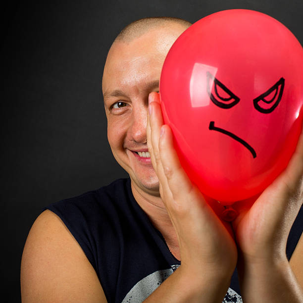 istock Happy man hiding behind angry balloon 177441656