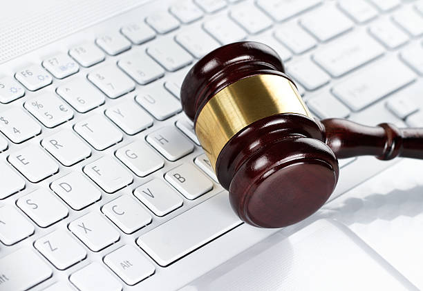 A judges gavel lying across a white keyboard