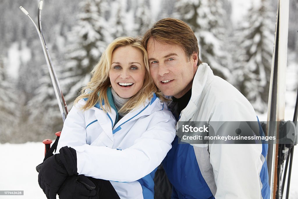 Meio envelhecido casal em férias de esqui nas montanhas - Foto de stock de Casal royalty-free