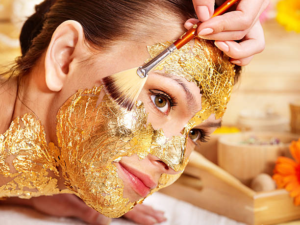 istock Woman getting face painted in gold 177443636