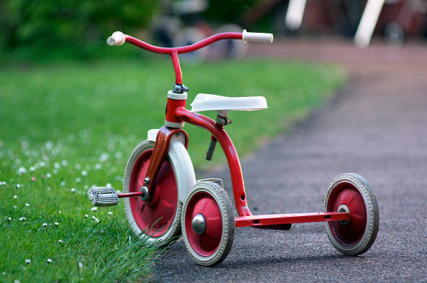 tricycle a red child tricycle in a garden tricycle stock pictures, royalty-free photos & images