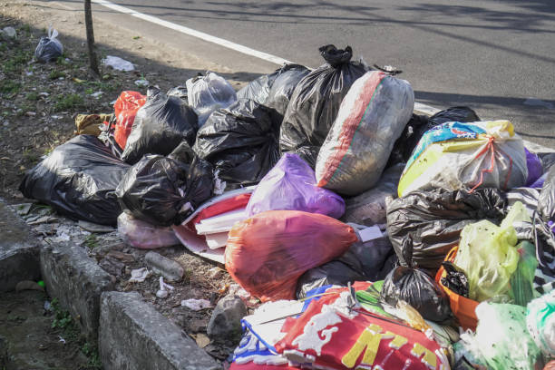 des tas d’ordures dans des sacs placés sur le bord de la route. des rues pleines d’ordures - packaging recycling bottle plastic photos et images de collection