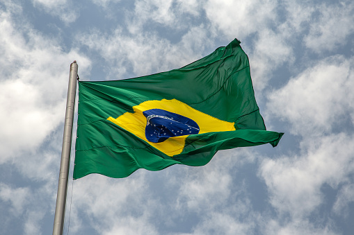 Goiânia, Goias, Brazil – September 30, 2023: A Brazilian flag fluttering in the wind on a day with many clouds in the sky.