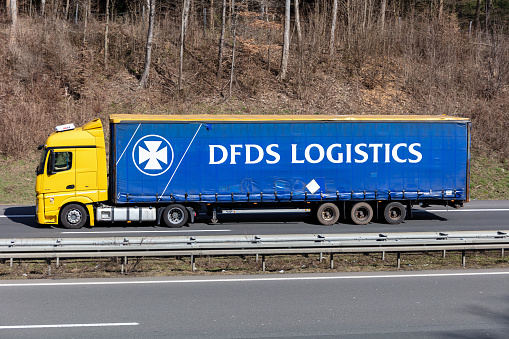 Wiehl, Germany - March 24, 2021: Mercedes-Benz Actros truck with DFDS Logistics curtainside trailer on motorway